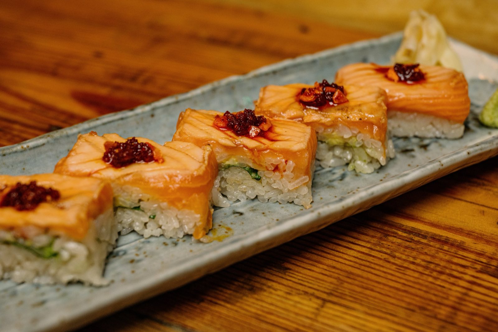 Pressed salmon sushi on a long ceramic plate
